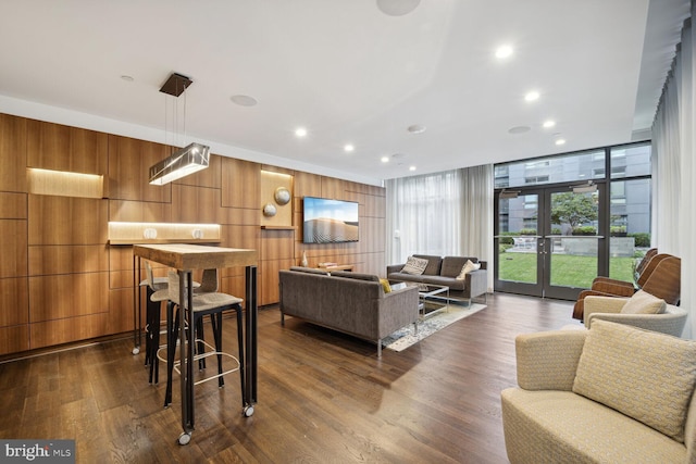 living room with dark hardwood / wood-style flooring, expansive windows, and french doors