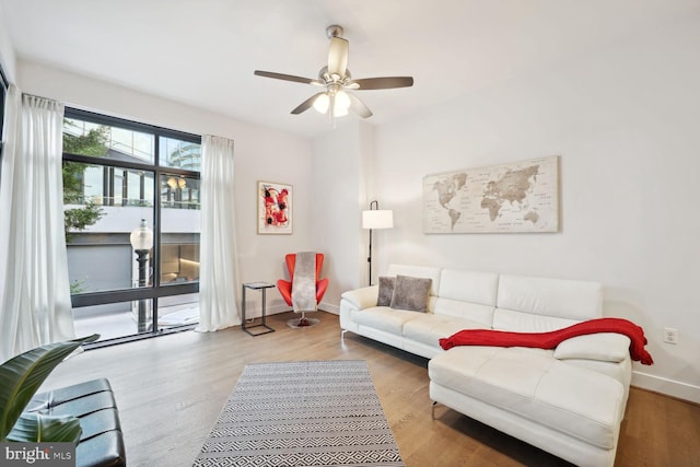 living room featuring hardwood / wood-style floors and ceiling fan