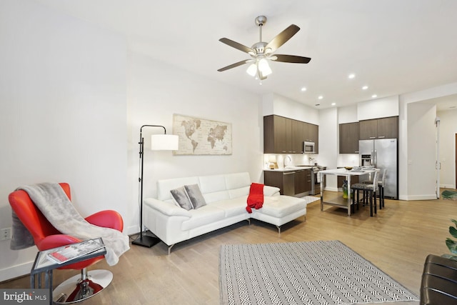 living room featuring ceiling fan and light hardwood / wood-style floors