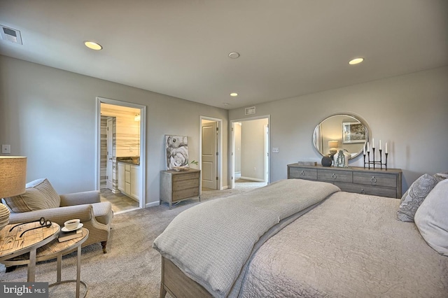 bedroom featuring light colored carpet and ensuite bath