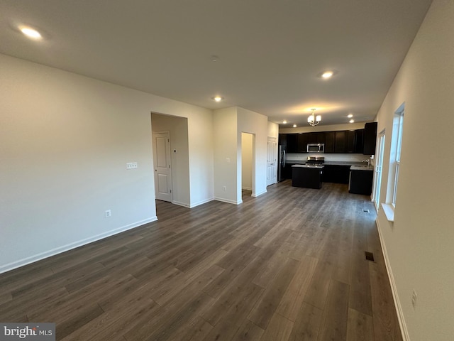 unfurnished living room featuring dark hardwood / wood-style floors and a chandelier