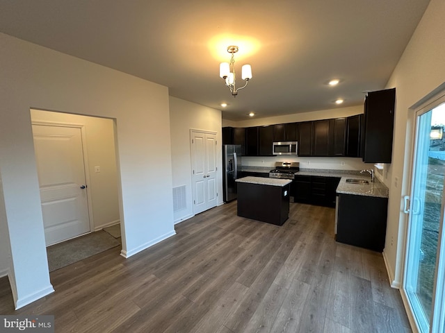 kitchen with sink, decorative light fixtures, a center island, hardwood / wood-style flooring, and stainless steel appliances