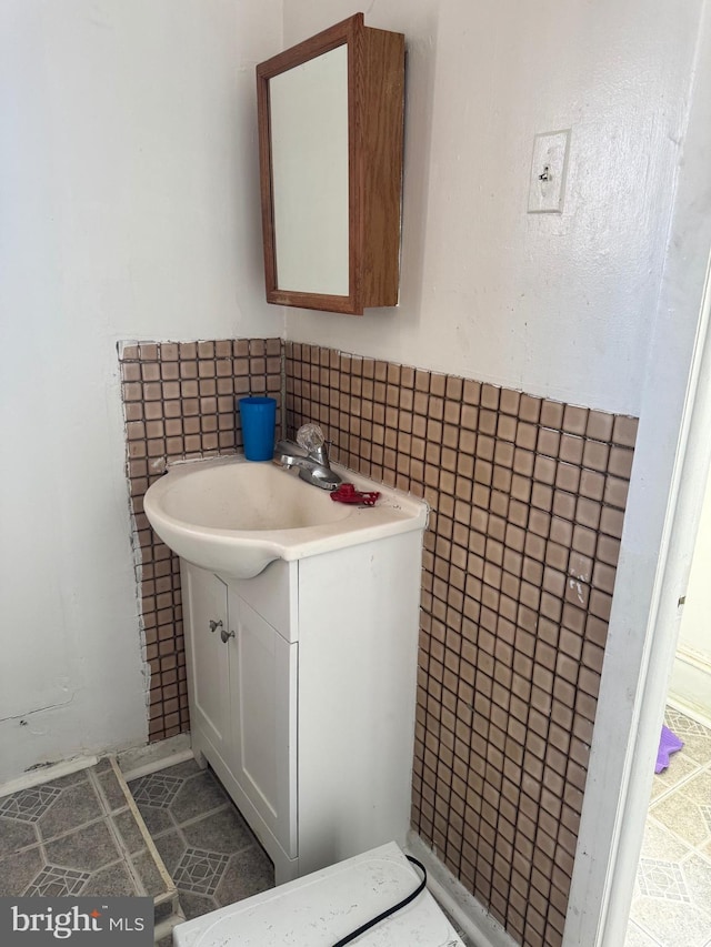 bathroom with tile walls, vanity, and tile patterned flooring