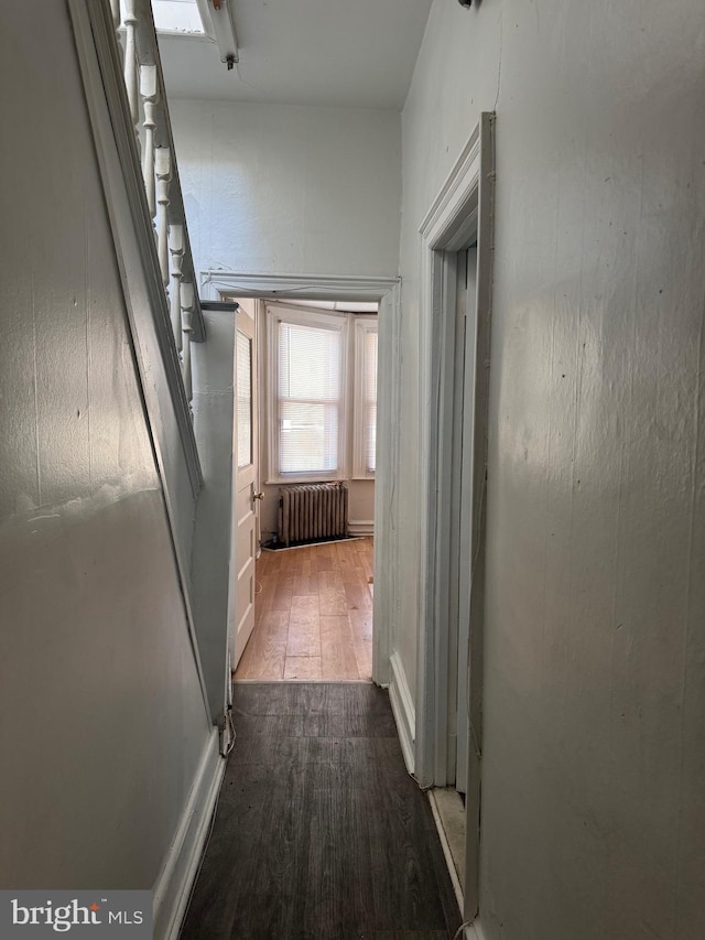 hall with radiator heating unit and wood-type flooring