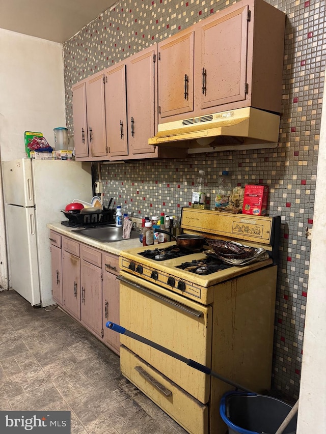 kitchen with white appliances, sink, decorative backsplash, and light brown cabinets