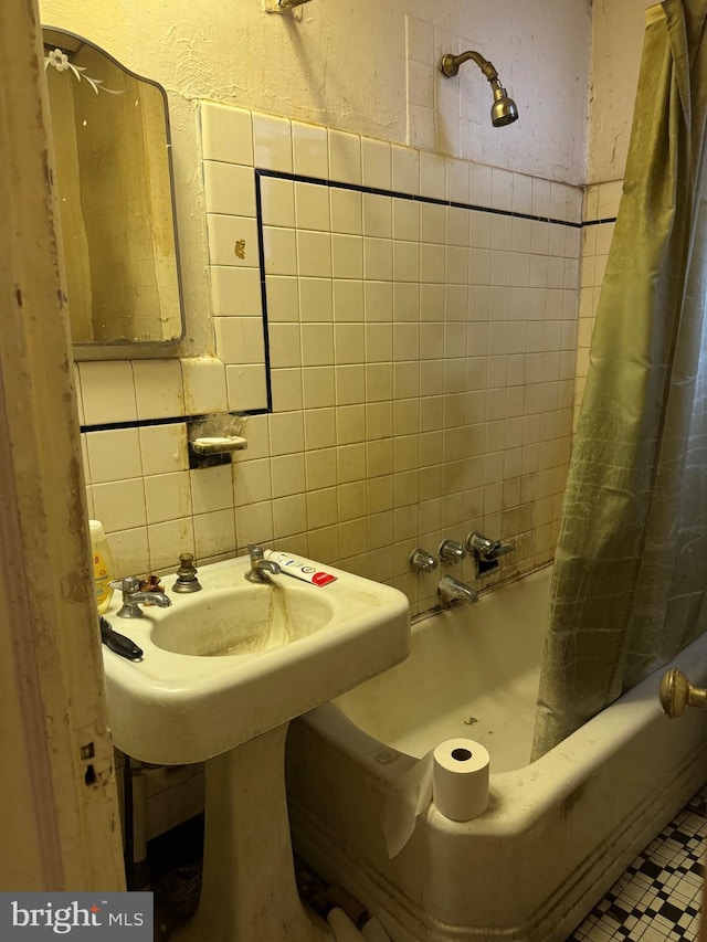 bathroom with shower / tub combo with curtain, tile walls, and backsplash