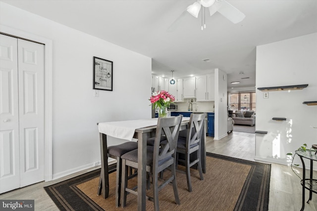 dining area featuring light wood-type flooring and ceiling fan