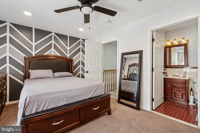 carpeted bedroom with ensuite bathroom and sink