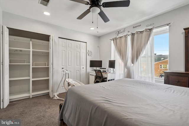 carpeted bedroom featuring ceiling fan and multiple closets