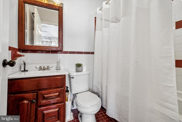 bathroom featuring tile patterned floors, a shower with curtain, toilet, tile walls, and vanity