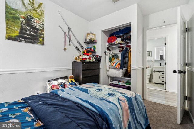 bedroom featuring sink, a closet, and carpet flooring