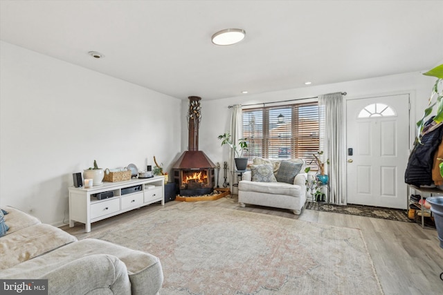 sitting room featuring light hardwood / wood-style flooring and a wood stove