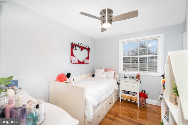 bedroom featuring ceiling fan, baseboards, and wood finished floors