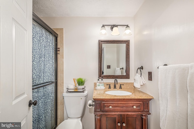 bathroom featuring a textured ceiling, vanity, and toilet