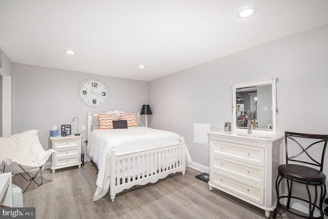 bedroom with baseboards, light wood finished floors, and recessed lighting