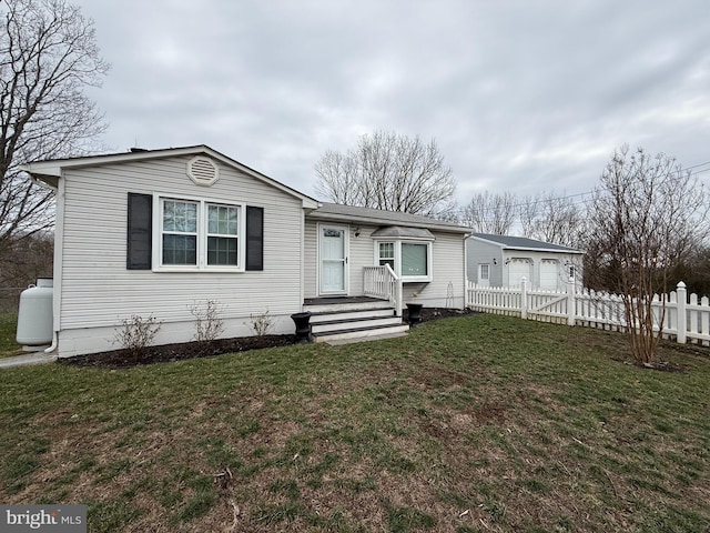 view of front of property featuring a front lawn and fence