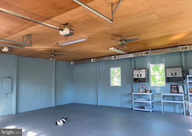 garage featuring a garage door opener and wooden ceiling