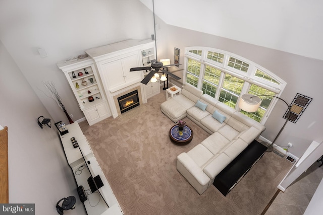 living room with light carpet, high vaulted ceiling, and ceiling fan