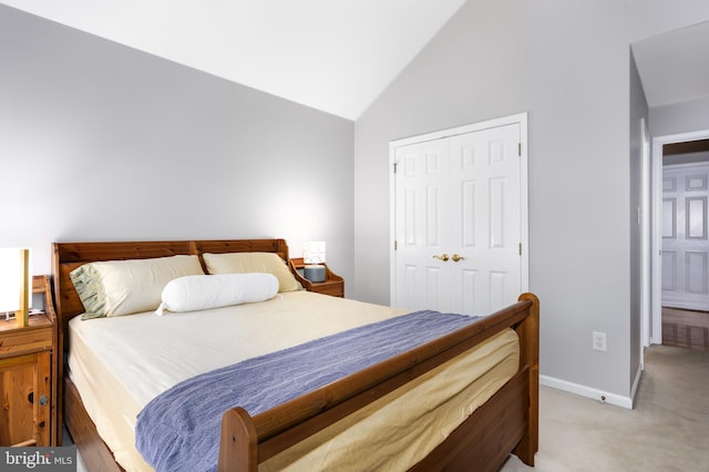 carpeted bedroom with lofted ceiling and a closet