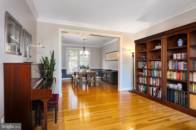 miscellaneous room with an inviting chandelier, crown molding, and light hardwood / wood-style floors