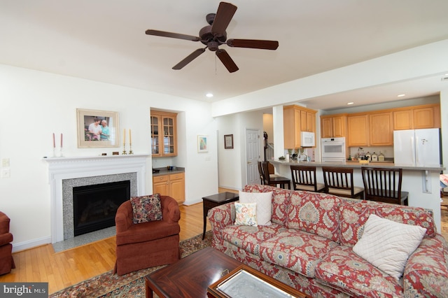 living room featuring ceiling fan and light hardwood / wood-style flooring