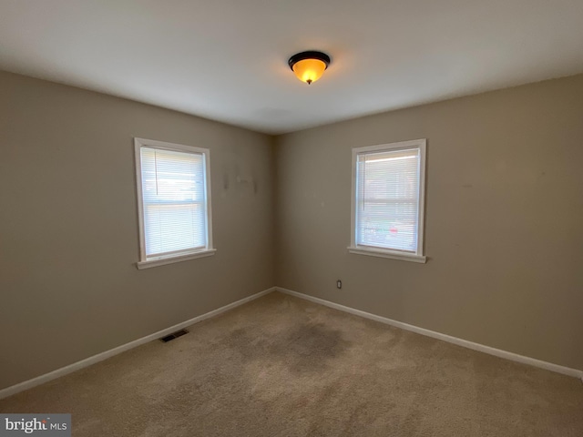 carpeted empty room featuring plenty of natural light