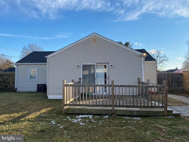 rear view of house featuring central AC unit, a lawn, and a deck