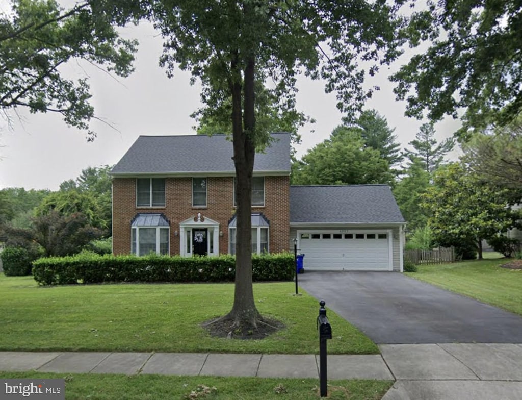 view of front of house with a garage and a front lawn