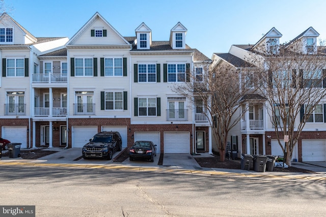 townhome / multi-family property with driveway, brick siding, and an attached garage