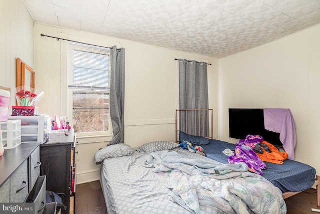 bedroom with dark wood-type flooring