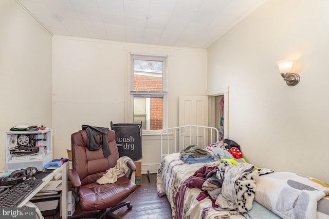 bedroom with crown molding and wood finished floors