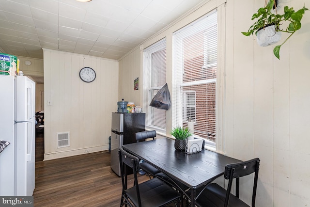 dining room featuring dark wood-style flooring, visible vents, and plenty of natural light