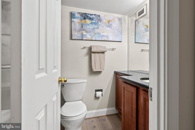 bathroom featuring vanity, toilet, and hardwood / wood-style floors