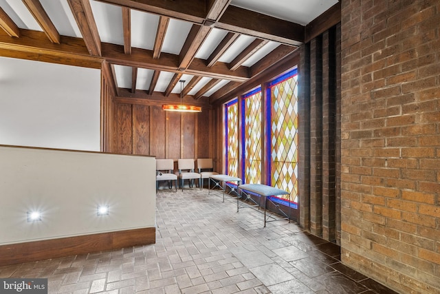 interior space with beamed ceiling and wooden walls