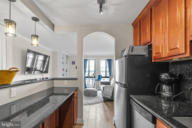 kitchen with decorative light fixtures, light wood-type flooring, dark stone countertops, dishwasher, and backsplash