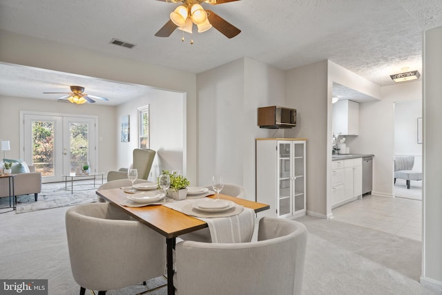 carpeted dining space with ceiling fan, a textured ceiling, and french doors