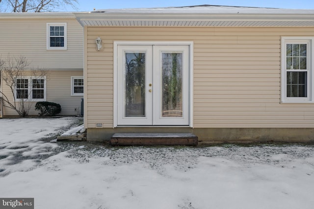 snow covered property entrance with french doors