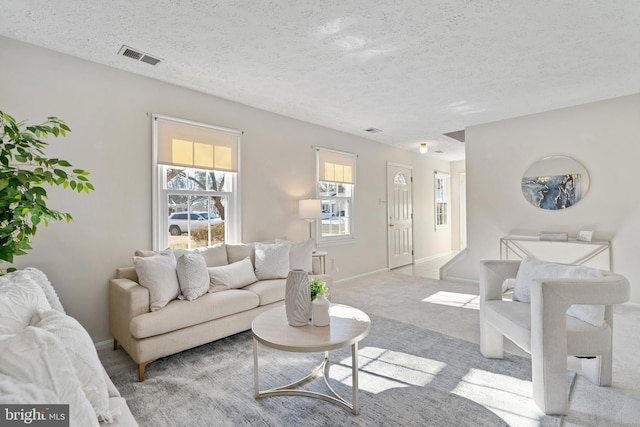 living room featuring light carpet and a textured ceiling