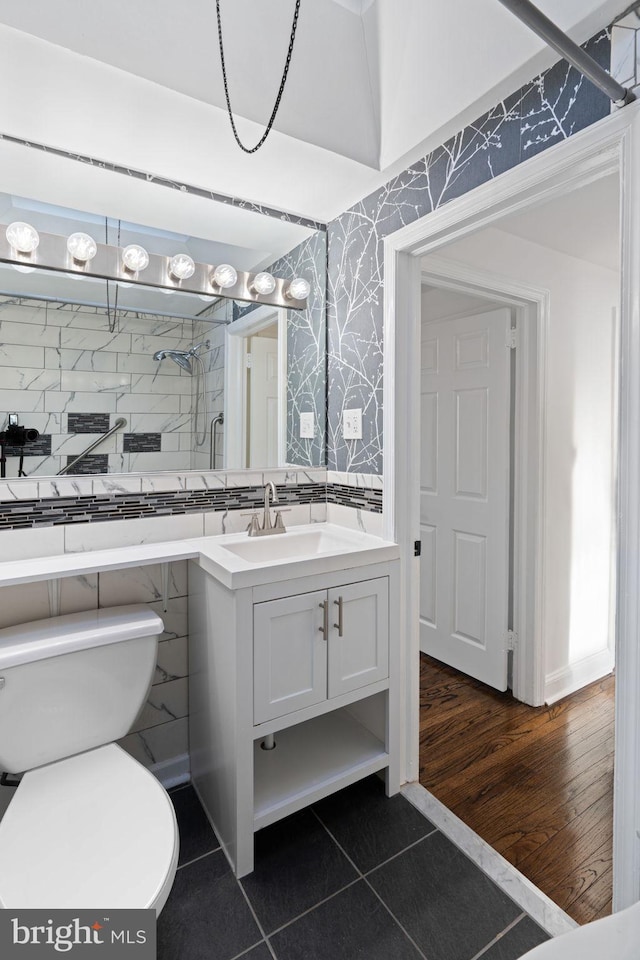 bathroom featuring vanity, tiled shower, tile patterned floors, and toilet