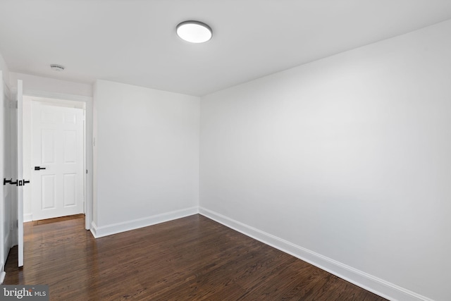 empty room with dark hardwood / wood-style flooring