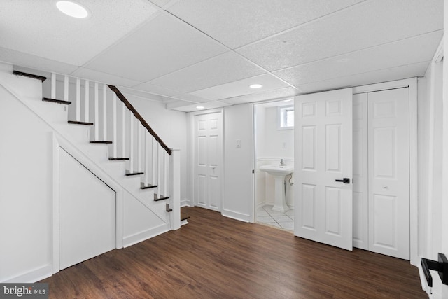 basement featuring dark hardwood / wood-style floors and a drop ceiling