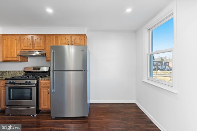 kitchen featuring dark stone countertops, crown molding, stainless steel appliances, and dark hardwood / wood-style floors