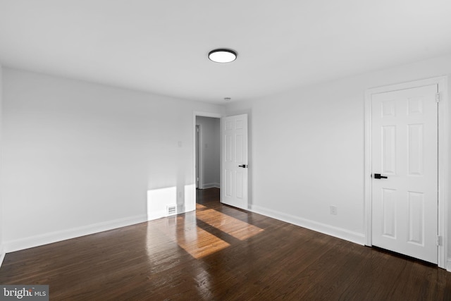 empty room featuring dark hardwood / wood-style flooring