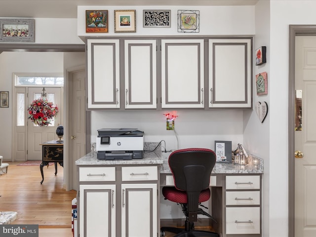 office area featuring light wood finished floors and built in desk