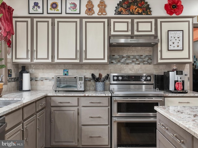 kitchen with range with two ovens, a toaster, under cabinet range hood, and gray cabinetry