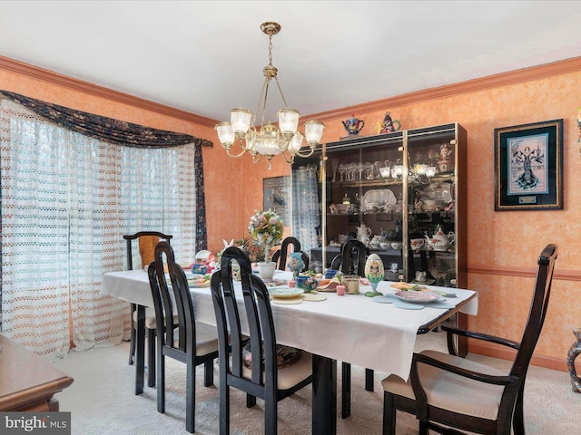 dining area featuring wallpapered walls, a chandelier, crown molding, and carpet flooring