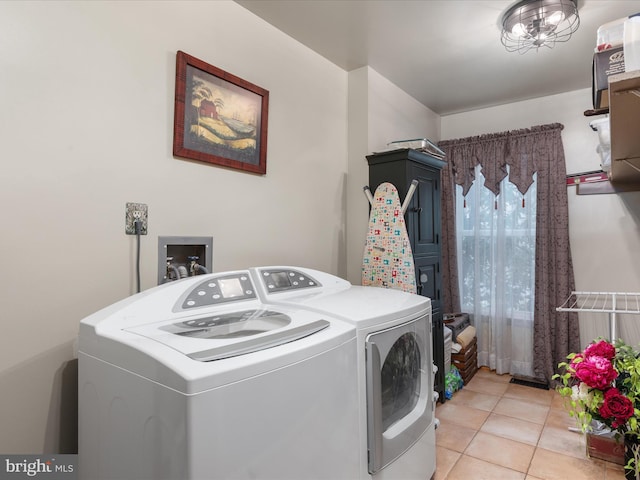 clothes washing area featuring laundry area, light tile patterned floors, and separate washer and dryer