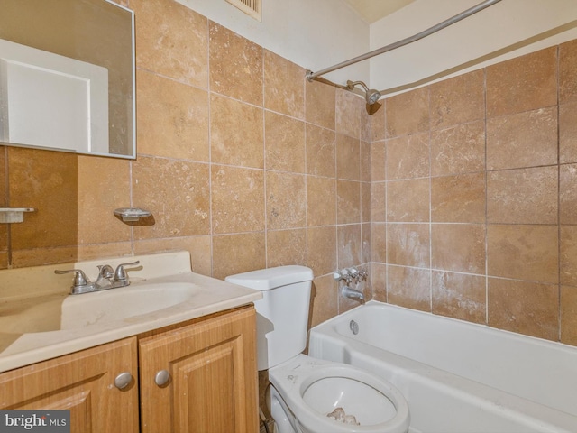 full bathroom with vanity, tiled shower / bath, tile walls, and toilet