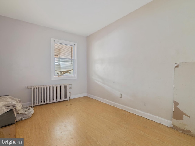 empty room featuring hardwood / wood-style flooring and radiator