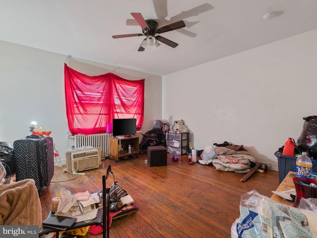 interior space with ceiling fan, radiator heating unit, and wood-type flooring